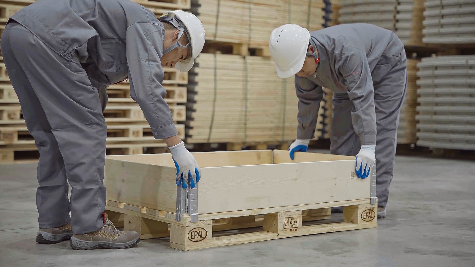 Workers assembling pallet collar with safety equipment